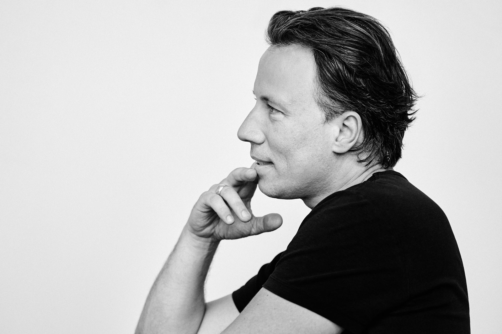 Portraitfoto des Dirigenten Kristian Järvi, der im Profil nach links blickend zu sehen ist